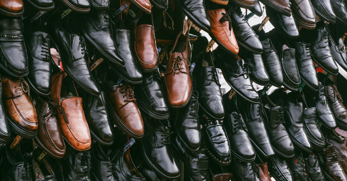 Various leather shoes in black and brown on display, creating a vintage aesthetic.
